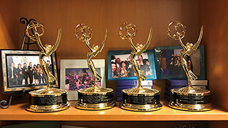 A shelf with 4 Emmy awards