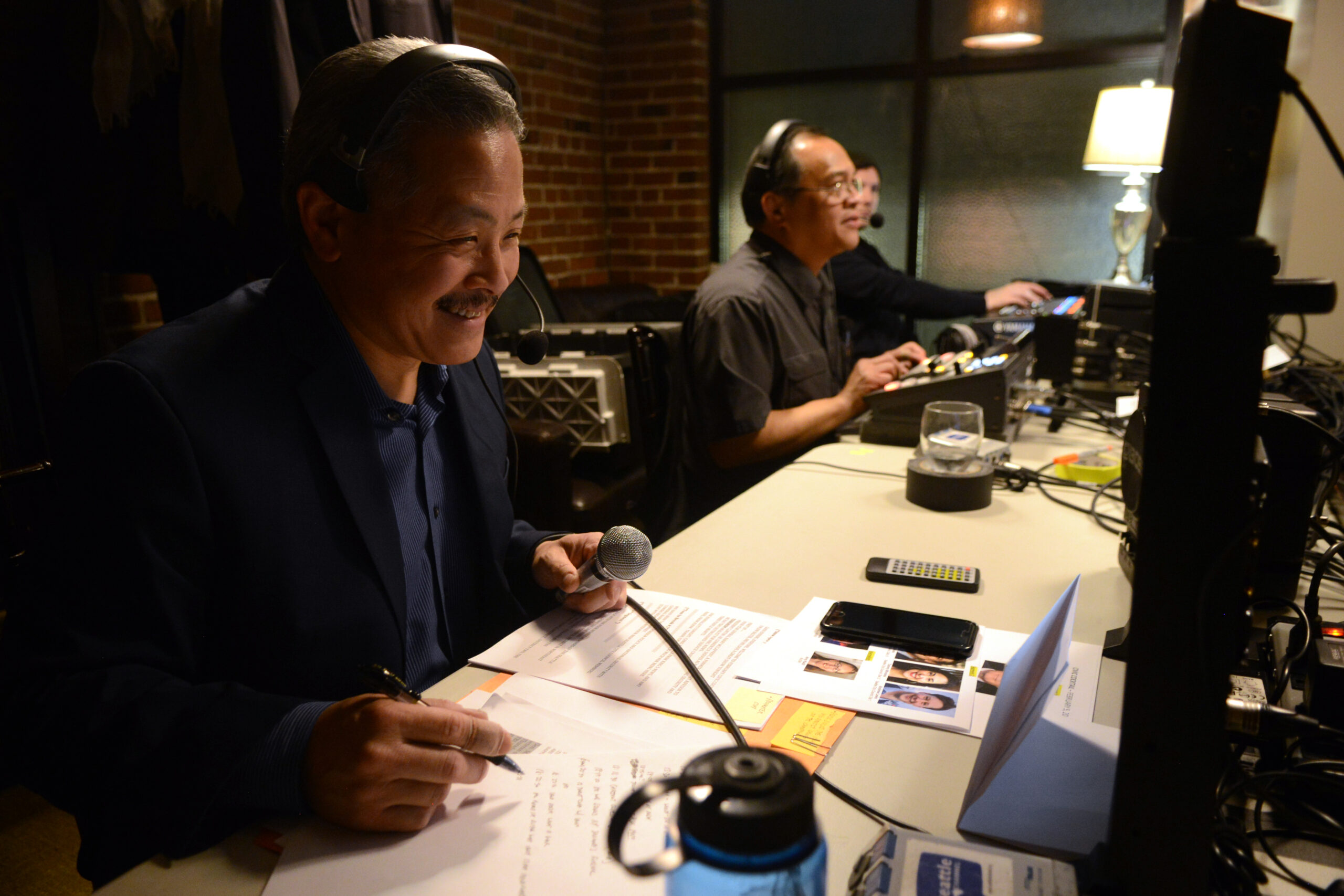 Norm Ohashi, left, works behind the scenes during a filming of Civic Cocktail. Ed Escalona is to the right.