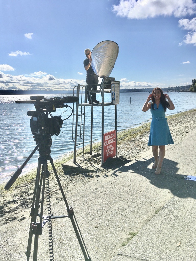 There's no job too low or too high for Norm. Here, he uses a light reflector while on a production with CityStream host Tatevik Aprikyan. Photo: Seattle Channel