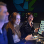 Susan Han wears a headset in a studio control room.